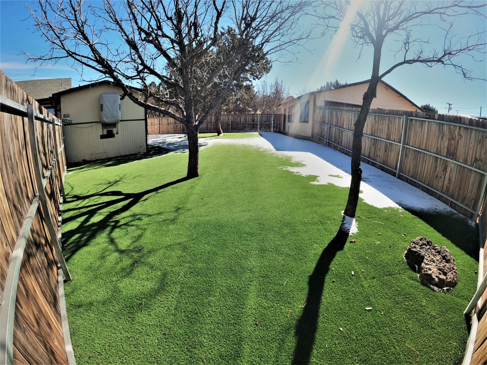 fenced in yard for kids to play with turf