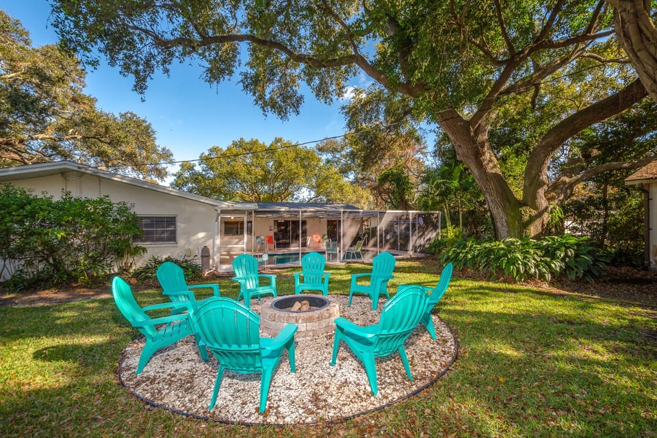 Large private backyard with custom fire pit surrounded by white sea shells.