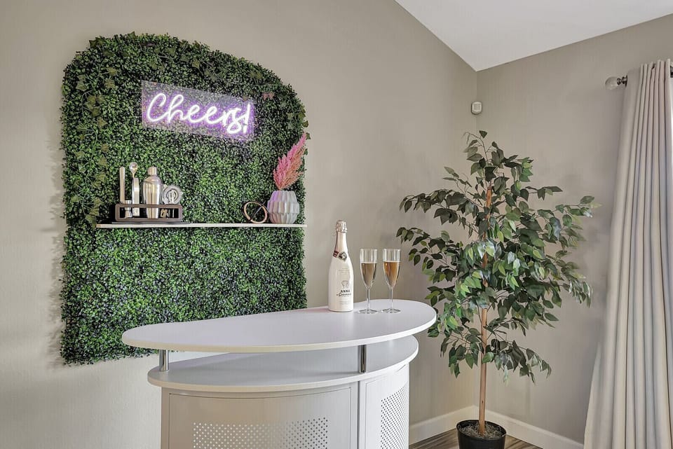 Here's perfect photo spot with chic plant wall in front of neon Cheers sign!