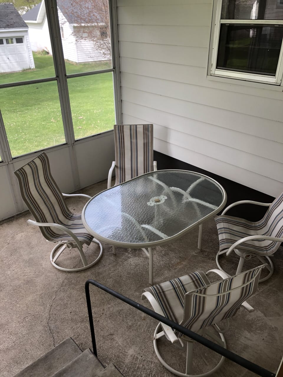 Screened in porch with table, chairs and bistro lights