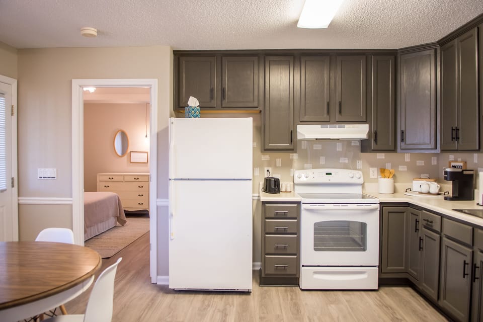 Kitchen with primary bedroom door shown beside. 