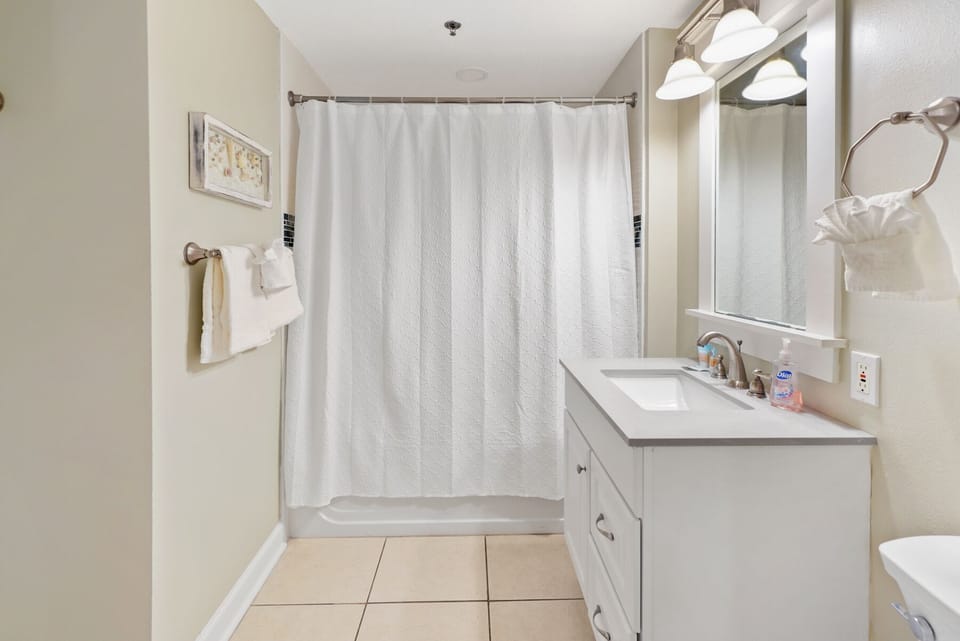 Your private bathroom features a relaxing tub-shower combo with fresh towels and modern vanity for your comfort.