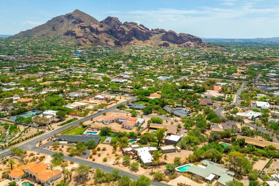 Aerial view of a residential neighborhood with mountain backdrop and clear skies.