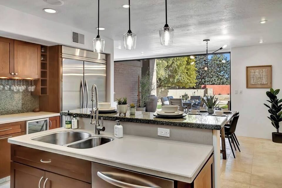 Modern kitchen with granite countertops and a view of the outdoor dining area.