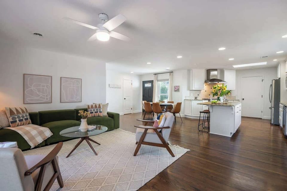 Bright and airy open-concept living space with stylish décor, cozy seating, and a fully equipped kitchen—perfect for relaxing or entertaining.