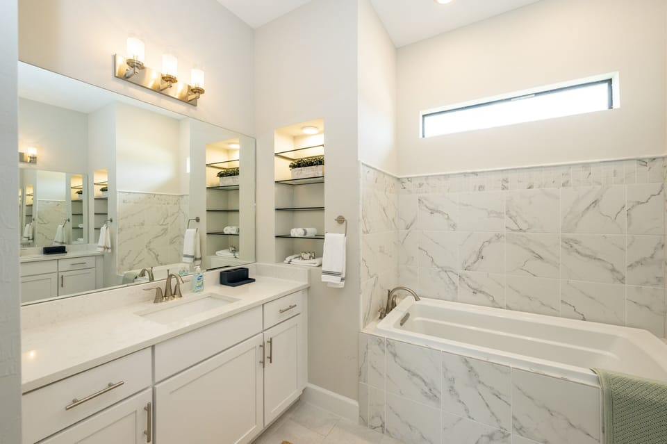 Master bathroom (view 1) with a tub and shower