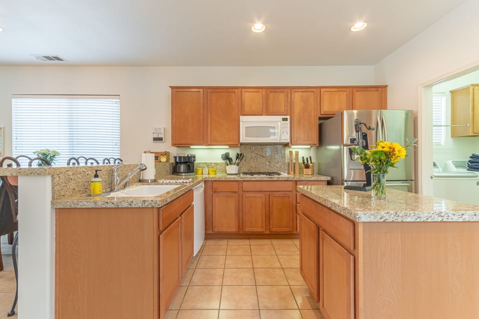 Kitchen sideview. Center Island, Gas Range,  Fridge with water and ice