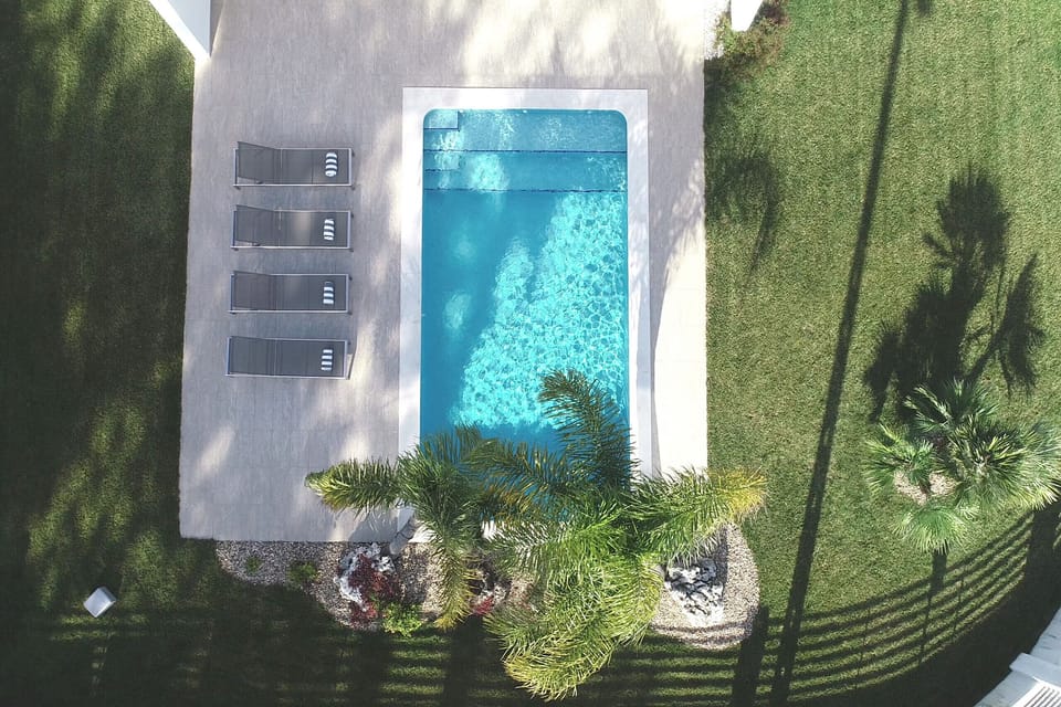 Aerial view of rectangular swimming pool with turquoise water — Villa Sassi, luxury holiday villa in Aroeira