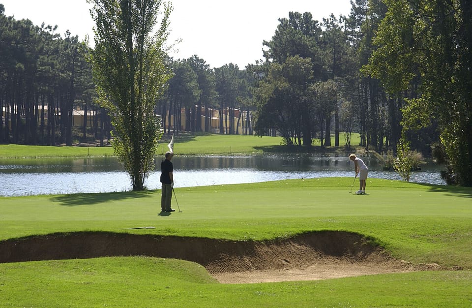 Golf course with water hazard and tree-lined fairway — Villa Sassi, luxury holiday villa in Aroeira