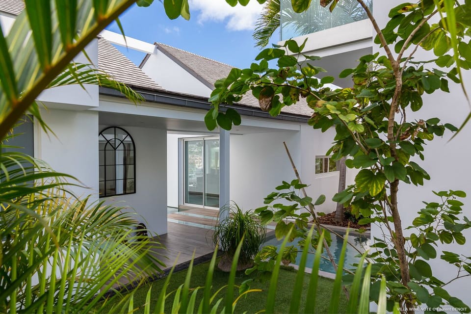 Outdoors: Tropical and lush garden with a nice green lawn and dramatic ocean views