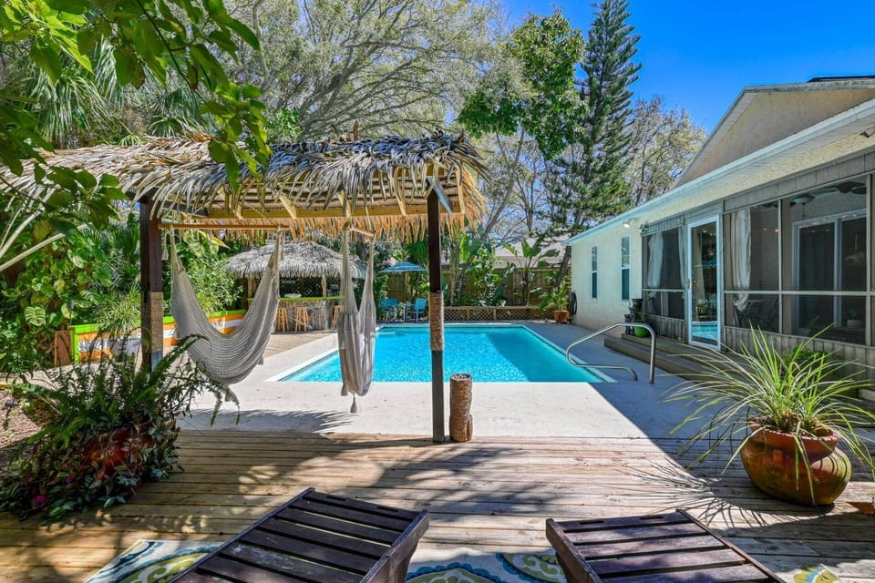 Soak up the sun in this gorgeous backyard paradise, complete with a pristine pool, tiki bar, and Florida sun room.