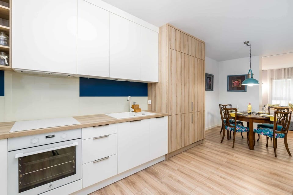 A compact kitchenette with white cabinets, a stovetop, and a microwave for convenient cooking.