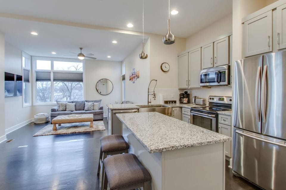 The full open kitchen with center island flows into the living area.