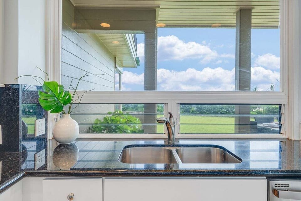Kitchen workspace with dual sink, generous counter space, and views that add light and openness to meal preparation.