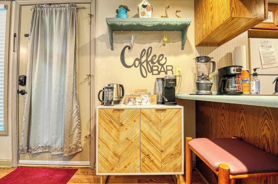 A stocked coffee bar with 3 coffee makers, an electric tea kettle, and supplies