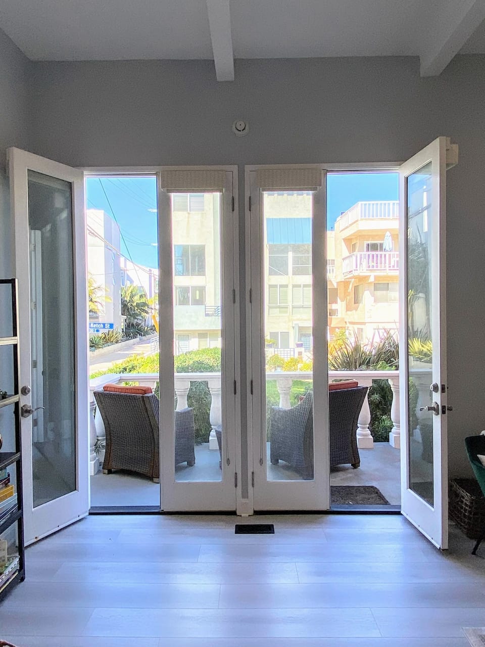 Tall double doors open from living area to front patio, with views.