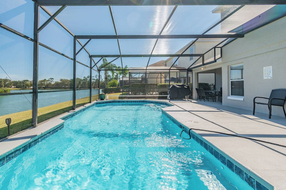 Step into your private oasis, where a sparkling pool surrounded by spacious patio awaits. Enjoy the serene water views while basking in the sunlight, framed by a protective screen that enhances your outdoor experience.