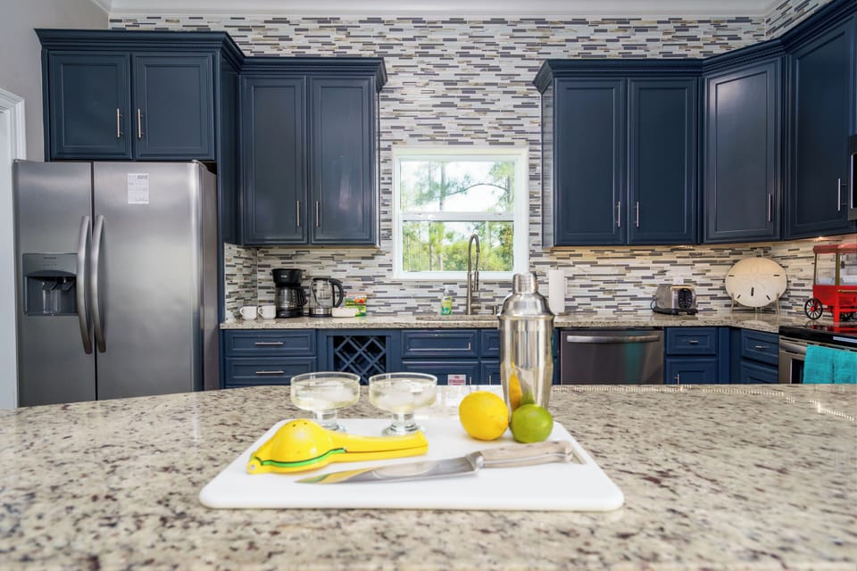 The large kitchen is well equipped with dishes, glasses, utensils, pots, & pans.