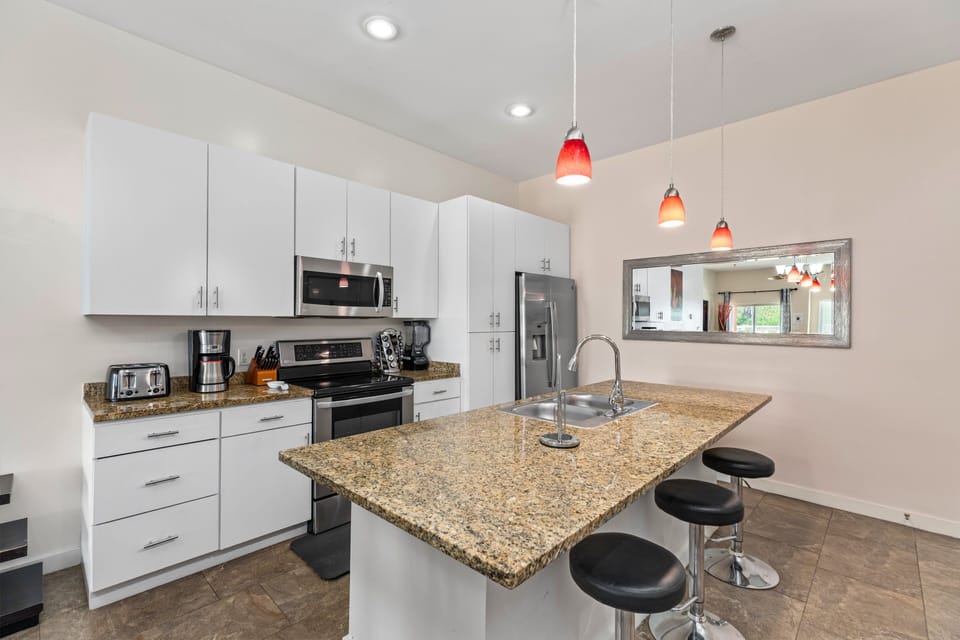 Stylish kitchen with stainless steel appliances and large center island/bar.