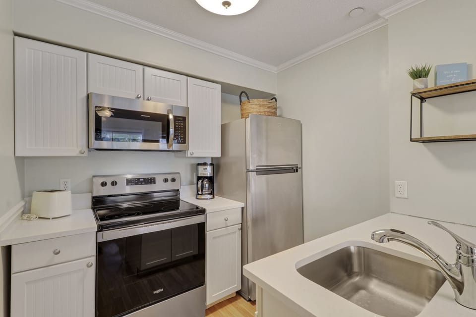 Kitchen - New appliances and countertops in this bright, white kitchen.  Standard coffeemaker.