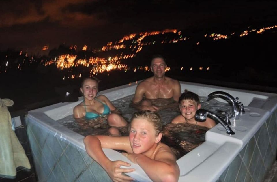The hot tub is on a tower, with city and rain forest below