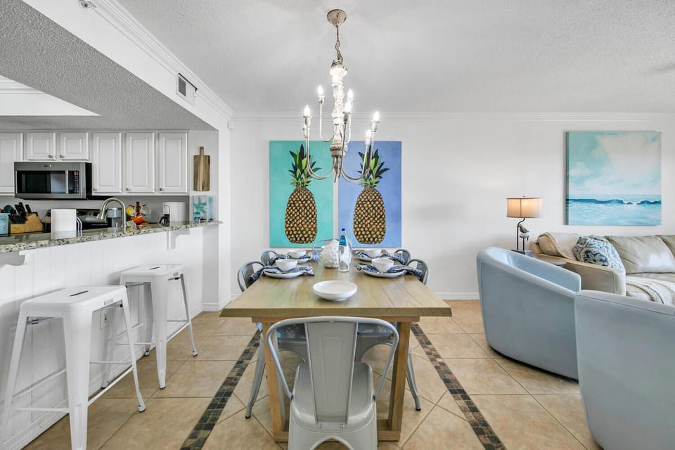 Your bright, coastal-inspired space flows from kitchen to dining to living area, perfect for gathering with ocean-themed art and modern comfort.
