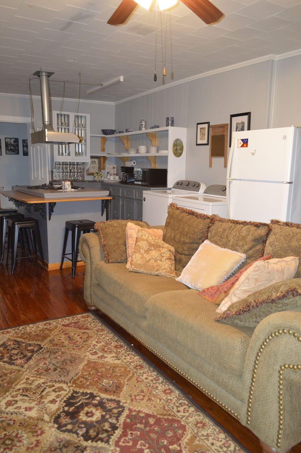 Large sofa opposite TV cabinet and 
a view of the kitchen.