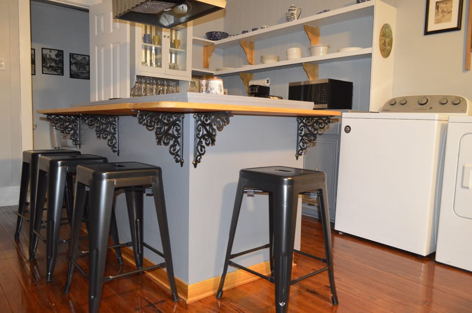 Stove top with cabinets surrounded
by four chairs.