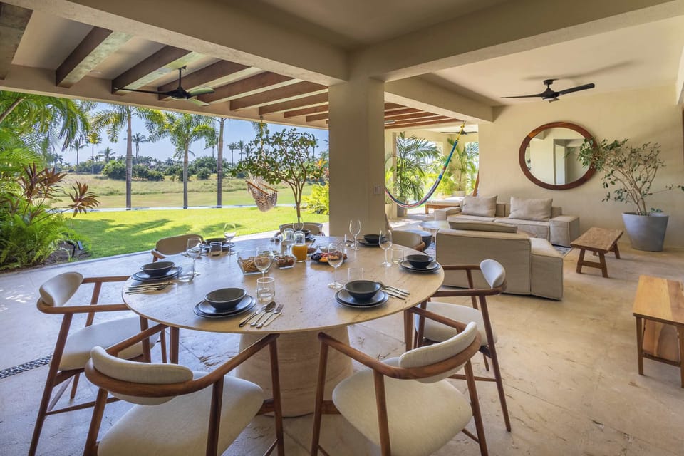 Expansive open-air dining and lounge area overlooking lush green views