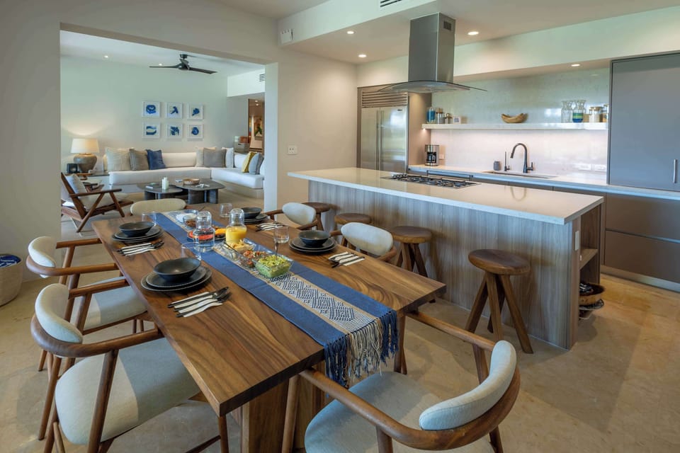 Contemporary dining area seamlessly connected to a fully equipped gourmet kitchen, featuring a spacious island and refined finishes — perfect for shared meals and effortless entertaining