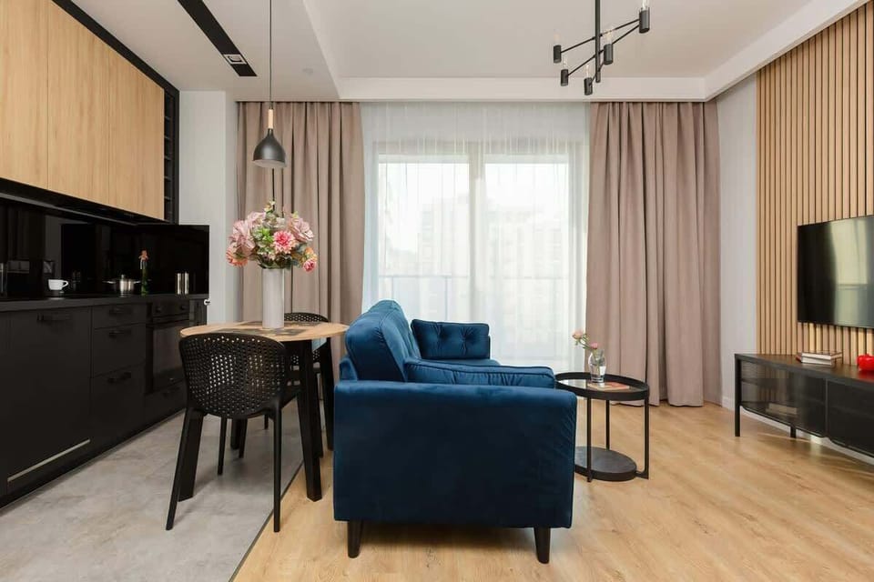 A closer look at the black and wood kitchen, with the dining table set for two. The setup is modern and inviting.