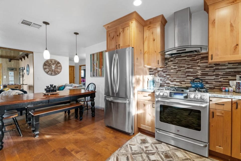 Bright kitchen w/ stainless appliances, stone backsplash, and easy flow to dining space.