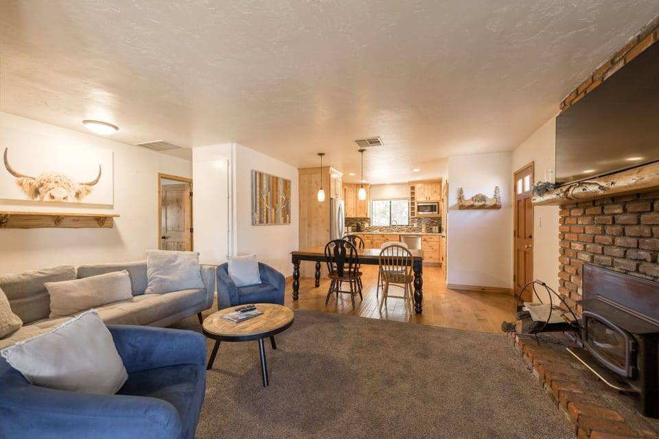 Living & dining room w/ brick fireplace for cozy snowy nights.