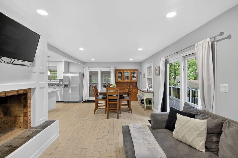 Bright open-plan living with deck access, fireplace, and modern kitchen.