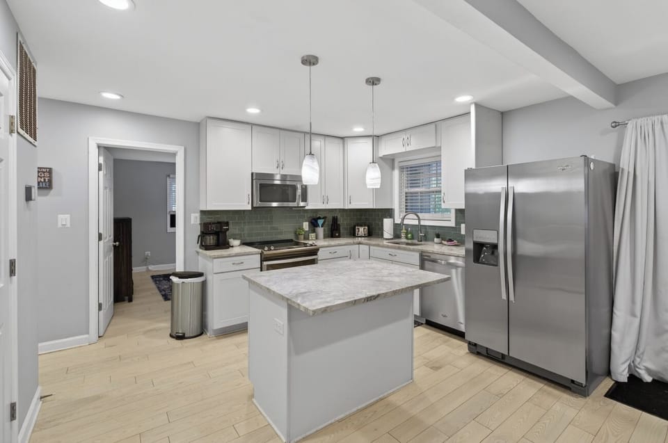 Modern kitchen with island, stainless appliances & chic backsplash