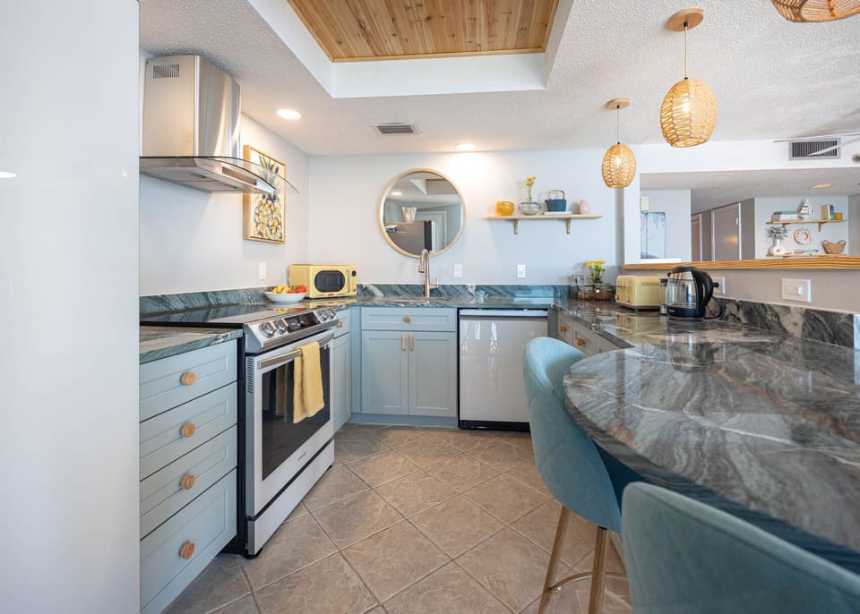 The kitchen features upgraded smart appliances, beautiful countertops, and a cozy breakfast bar for morning coffee