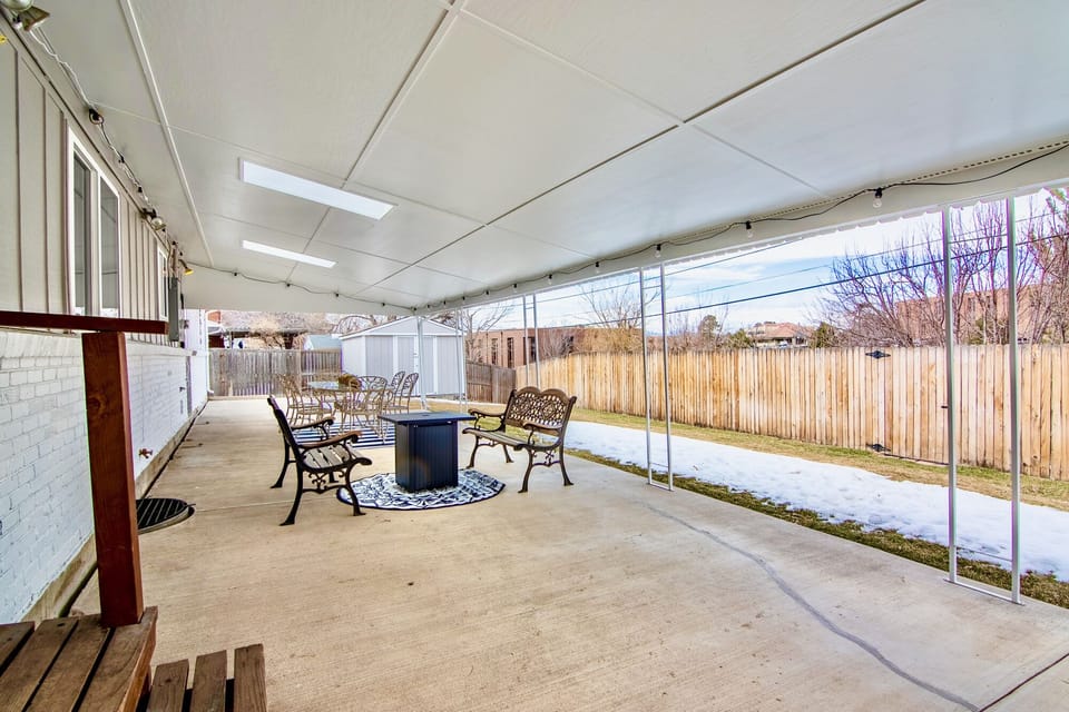 Large covered patio, 6 seated table and 2 bench seats around fire pit.