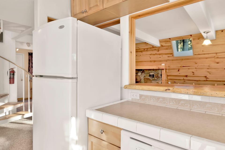Fully equipped cabin kitchen with ample cabinetry, stove, fridge, microwave, and coffee maker—perfect for cooking meals, morning coffee, and feeling right at home on your stay.