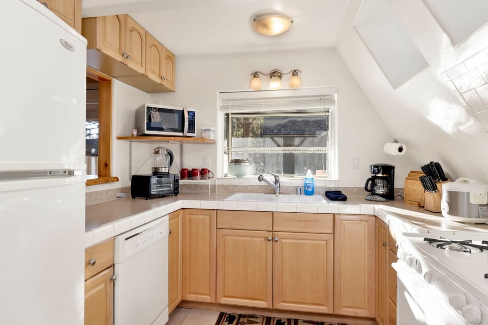 Fully equipped cabin kitchen with ample cabinetry, stove, fridge, microwave, and coffee maker—perfect for cooking meals, morning coffee, and feeling right at home on your stay.