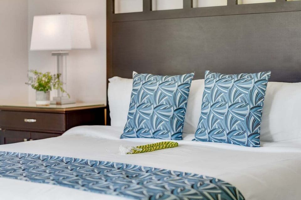 Stylish king bedroom featuring a padded headboard, crisp bedding, and coordinated accent pillows for a clean and inviting atmosphere.