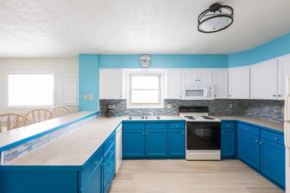 Fully stocked kitchen with full-size appliances, ample counter space, and breakfast bar seating.
