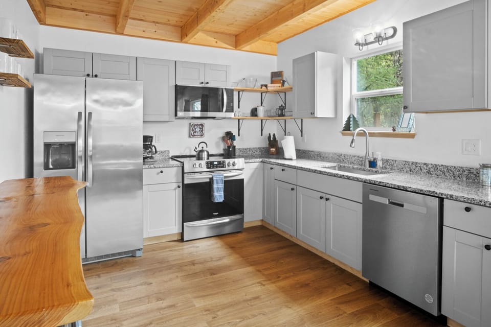 Cook with ease in a gourmet kitchen with modern appliances and forest views.