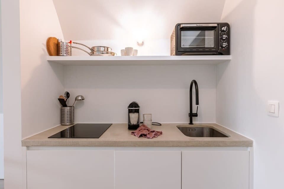 Compact kitchen with minimalist design and soft tones
