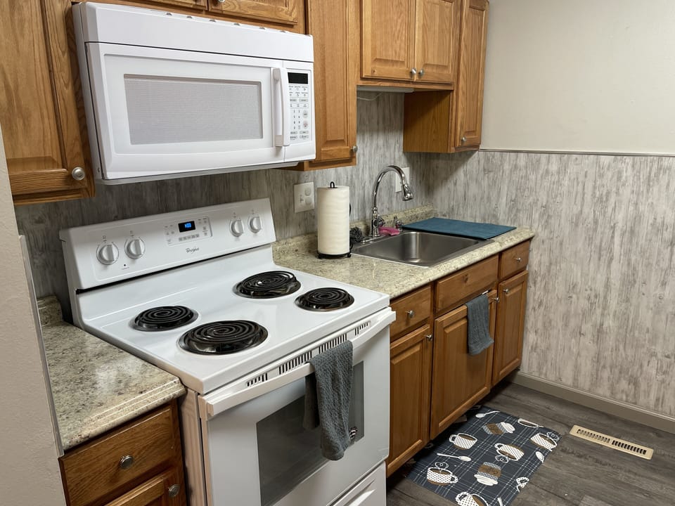 Kitchen with stove, fridge, and microwave.
