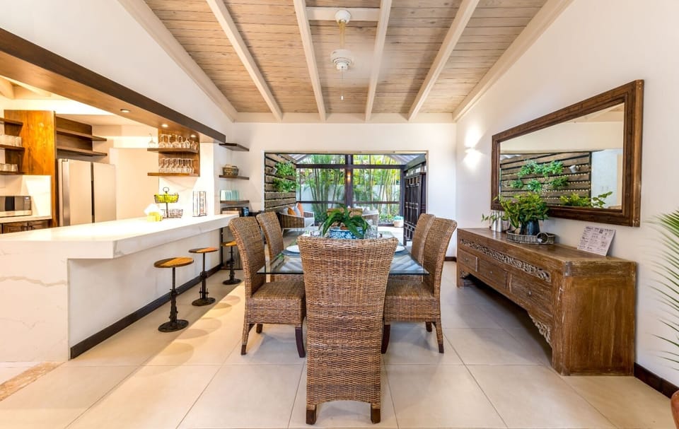Dining table w. seating for 6 and 4 bar countertop seats looking into kitchen.