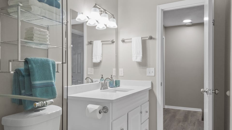 Renovated bathroom with stand up shower that features full ceramic tile surround