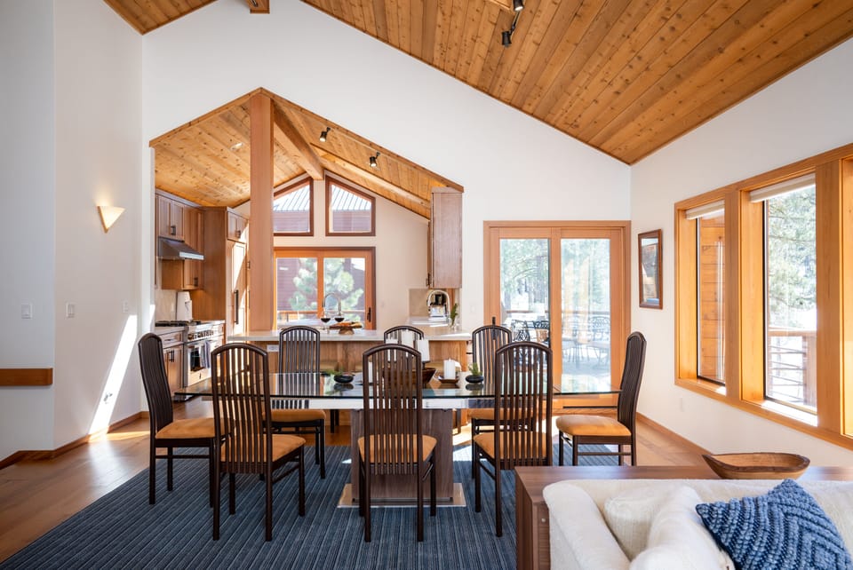 Alternative view from dining area showing well-equipped gourmet kitchen (remodeled in 2021) w/ breakfast counter and a sliding glass door leading to the deck off the kitchen and dining area