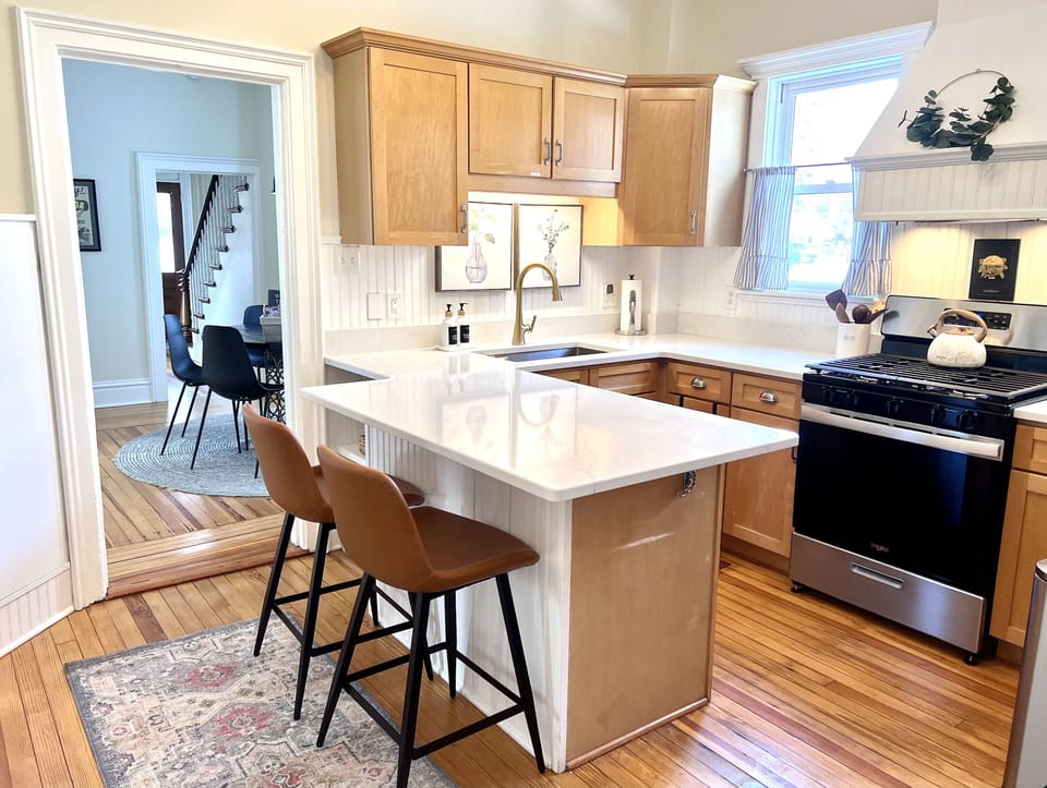 Kitchen fully stocked with dinnerware, glassware, and cooking pots/pans
