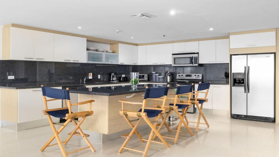 Gather around the stylish kitchen counter, which features seating for four, perfect for casual meals, morning coffee, or great conversation.