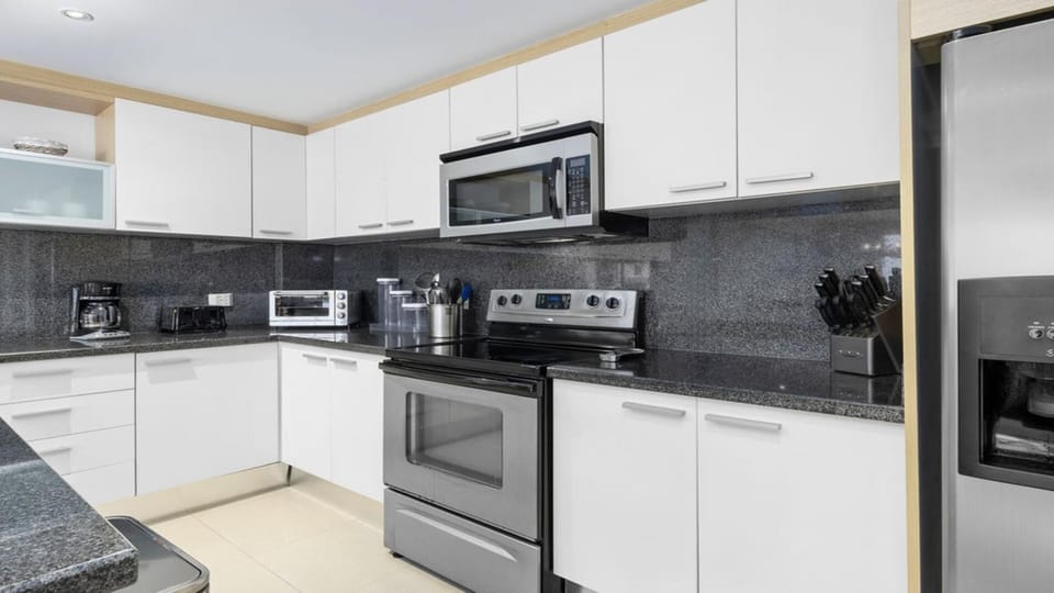 Cook like at home in a full kitchen equipped with sleek, modern appliances, everything you need for a comfortable and convenient stay.